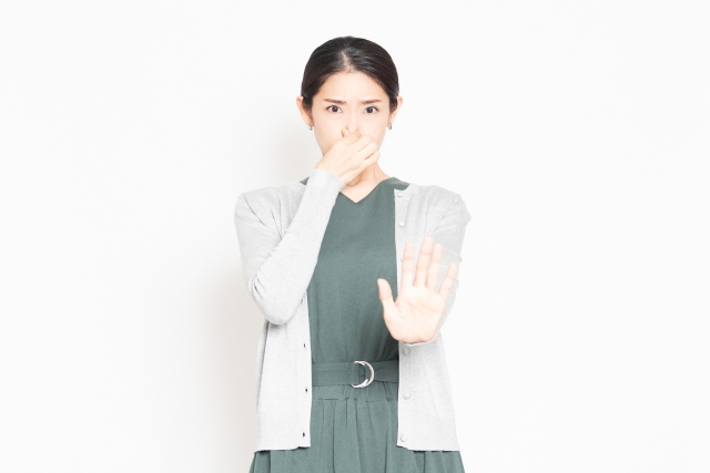 鼻をつまむ女性