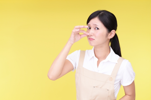 鼻をつまむ女性